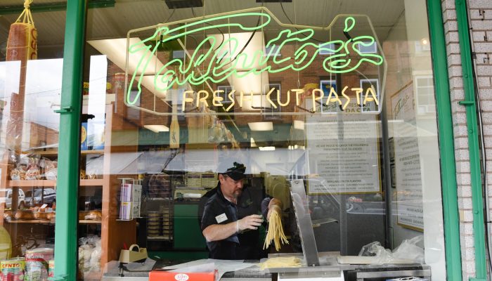 Man making pasta in a store window.