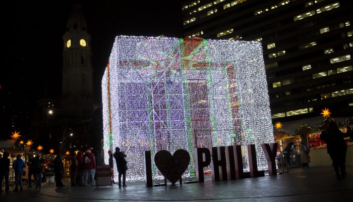 People gathered around the giant lit up present in love park