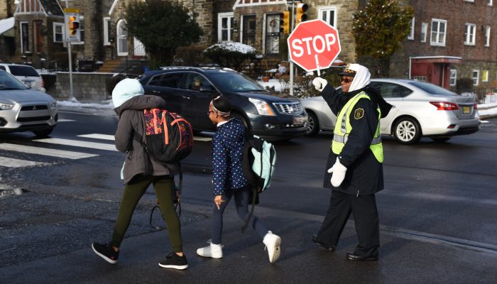 crossing guard helping children cross the street