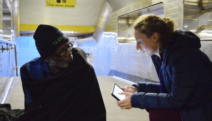 A PIT Count volunteer conducts a survey with someone on the street in 2017.