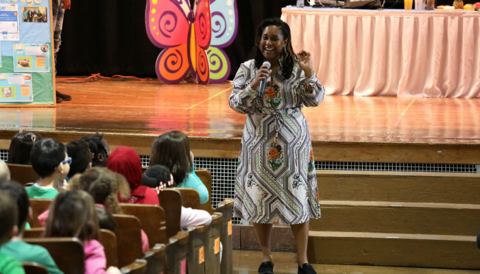 Teacher speaking to children in auditorium