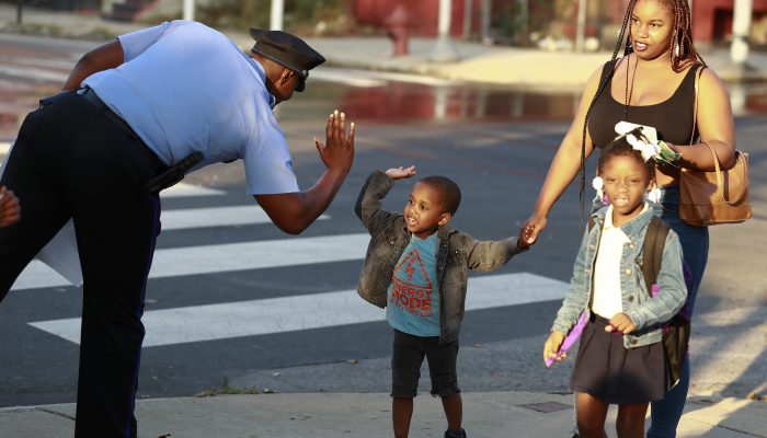 Philadelphia Police high fiving a child on the street