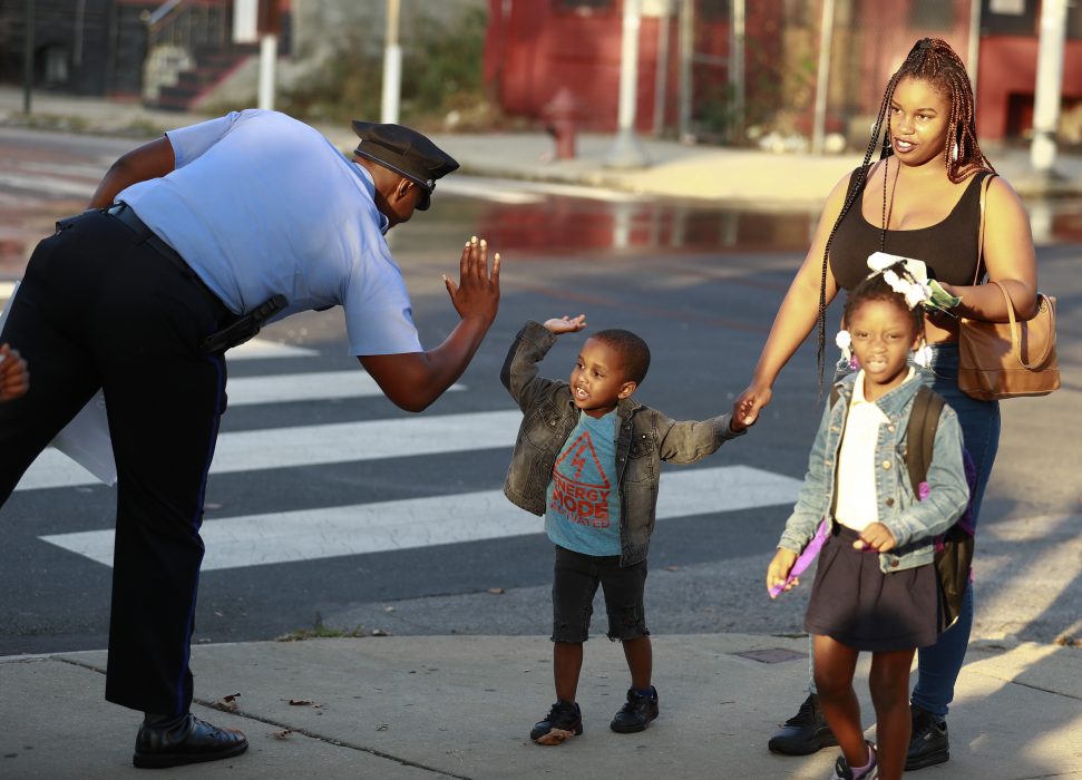 Philadelphia Police high fiving a child on the street