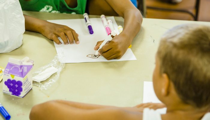 children drawing at table with juicebox