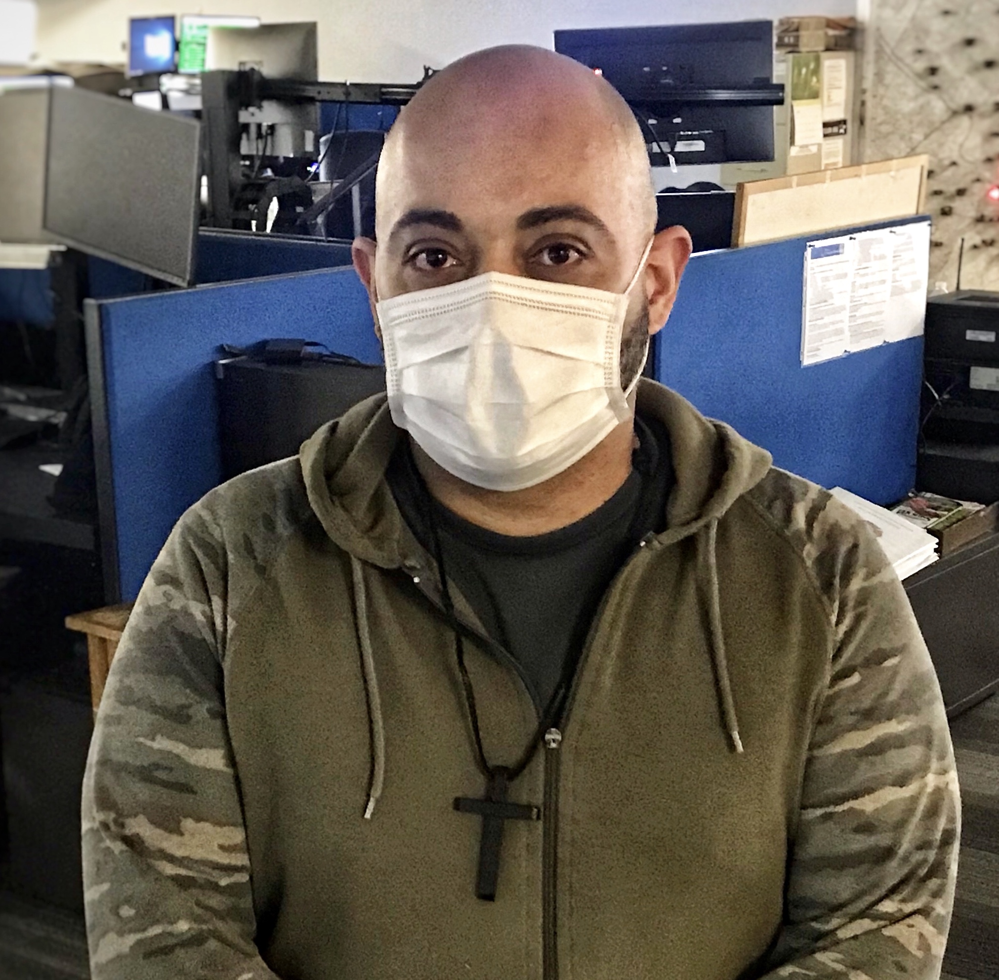 man in face mask inside call center with cubicles