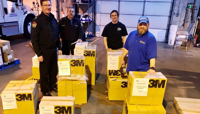 City staff in warehouse with boxes of Personal Protective Equipment.