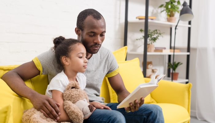 A father reads to his daughter