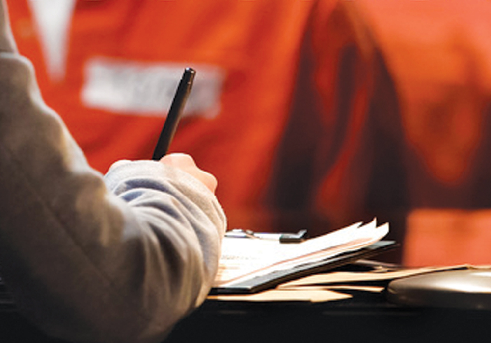 A person writes on a clipboard.