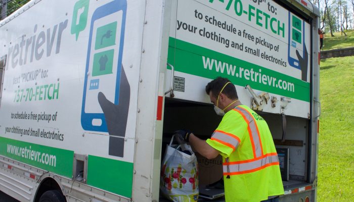 Retrievr employee picking up waste and putting it in the truck