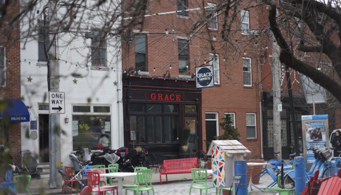tables and chairs spaced out in front of a restaurant