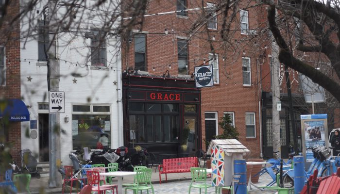 tables and chairs spaced out in front of a restaurant