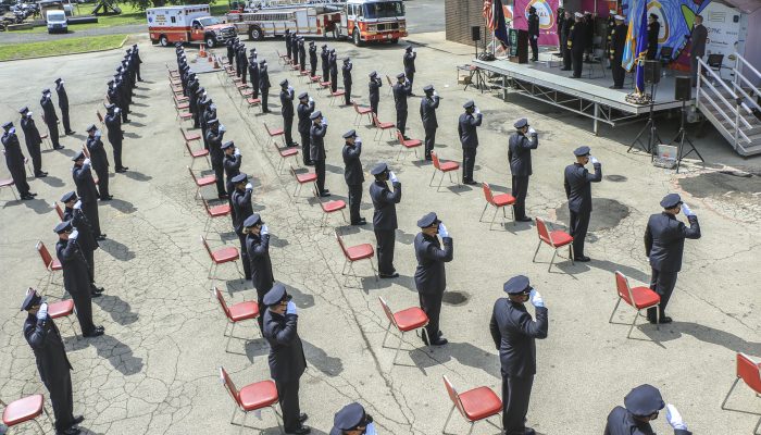 cadets standing on asphalt and saluting in daylight