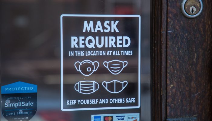 Sign on store window that says "mask required."