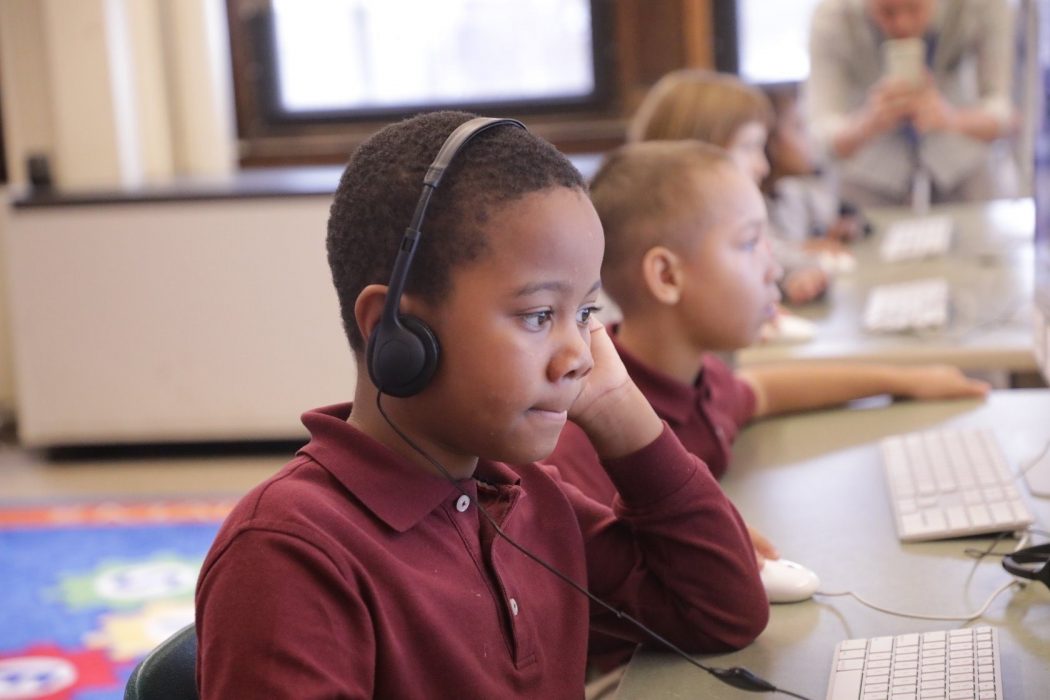 Kid with computer attending virtual classes