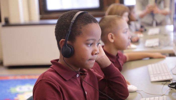 Kid with computer attending virtual classes