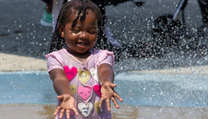 girl playing in sprinkler