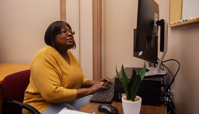 A woman looking at the Philly311 Online Learning Platform on her computer.