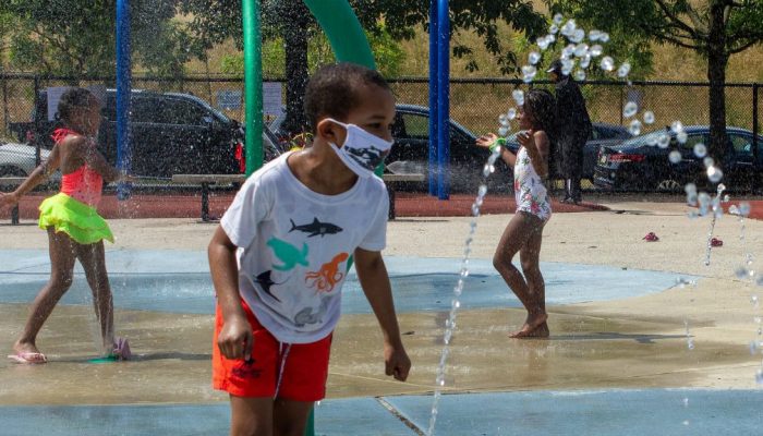 Un niño corre entre fuentes de agua en un parque de Filadelfia
