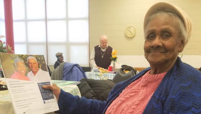 senior woman holding a brochure and smiling