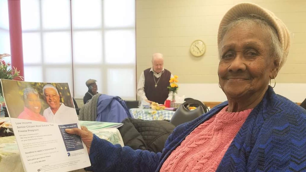 senior woman holding a brochure and smiling