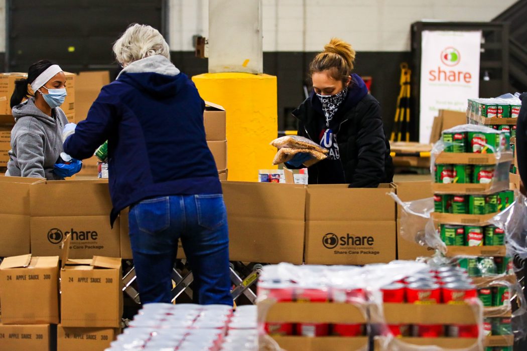 people packing boxes of food for the city's food distribution program