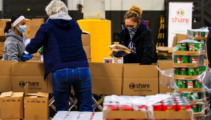 people packing boxes of food for the city's food distribution program