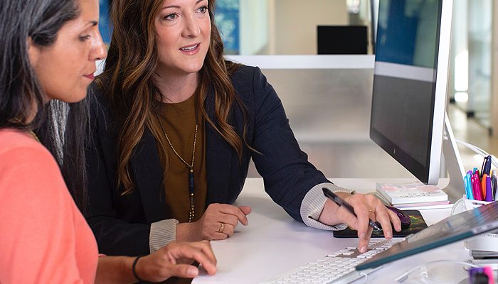 Duas mulheres olhando para uma tela de computador