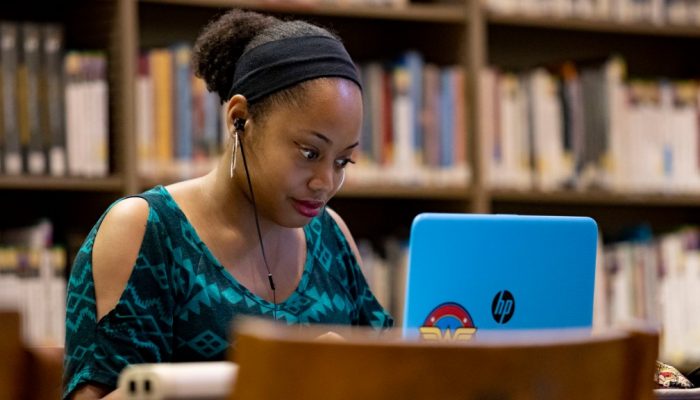 woman typing on computer in the library