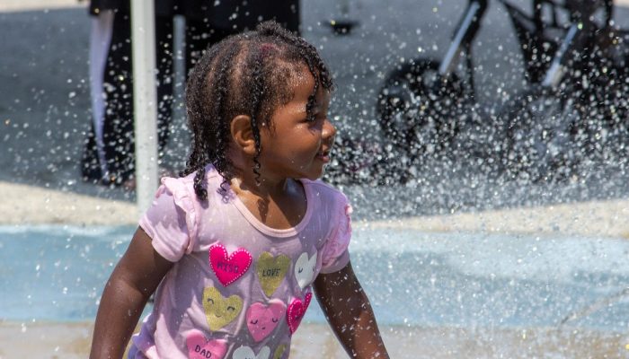 Una niña juega entre fuentes de agua en un parque de Filadelfia.