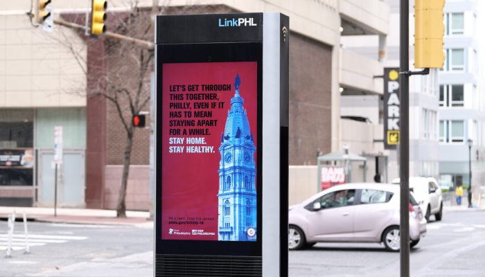 Electronic billboard with a message encouraging staying home and social distancing to prevent the spread of COVID-19.