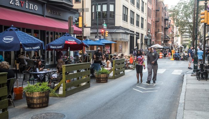 Diners eating at tables set up in a streetery in Philadelphia.