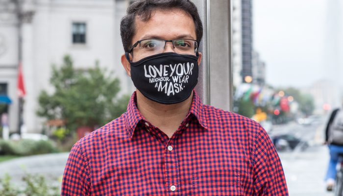 Jigar wearing a mask that says Love your neighbor. Wear a mask