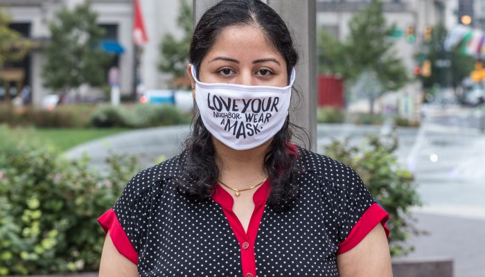 Bhumika wearing a mask that says love your neighbor, wear a mask