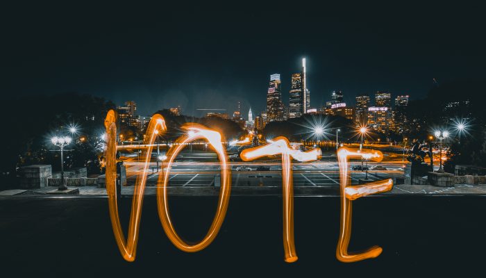 a light painting of the word vote with the philadelphia skyline in the background