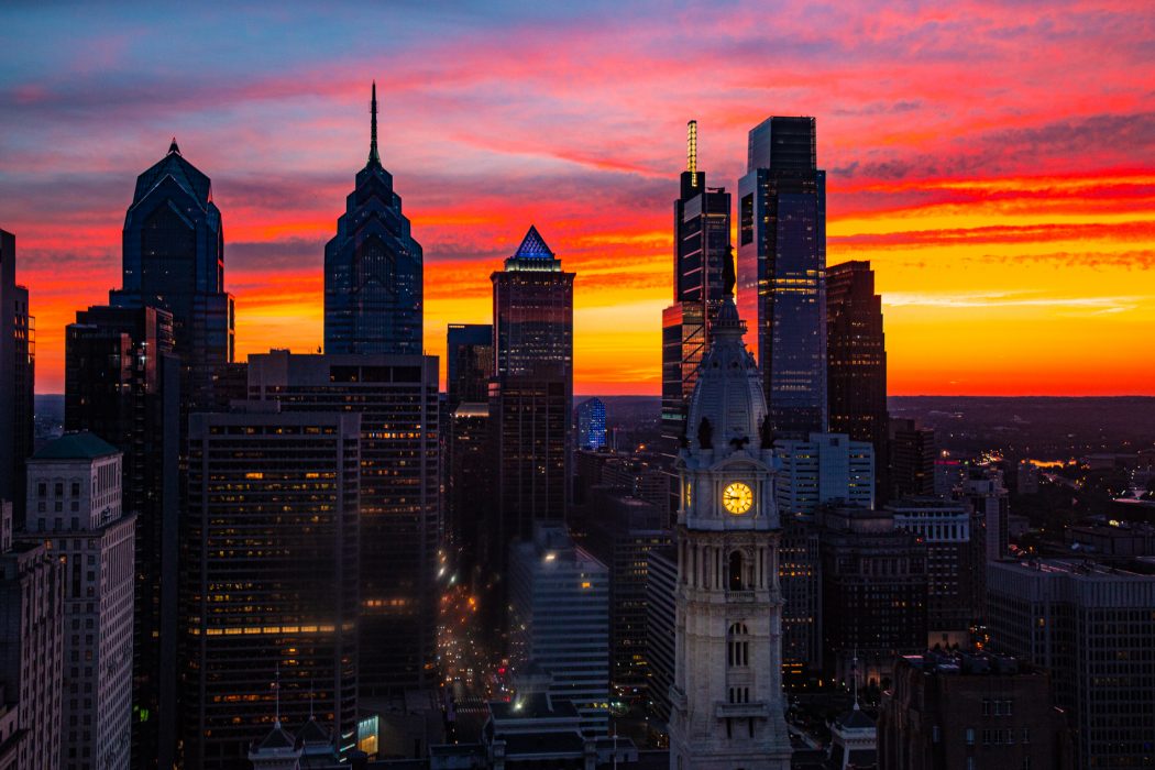 a vibrant sun set with the city of philadelphia skyline in the foreground