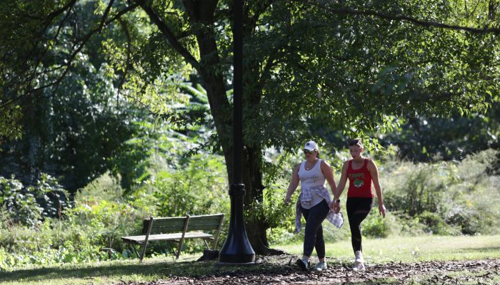Two women in athletic clothes walk along the Martin Luther King Trail.
