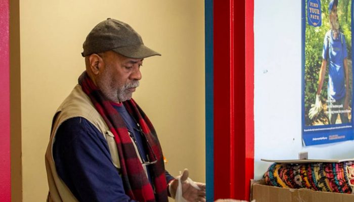 Senior Citizen stands at a doorway