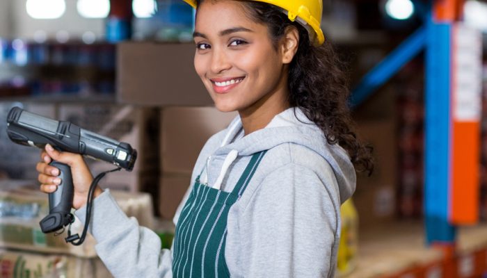 Woman holding a barcode scanner wearing a hard hat