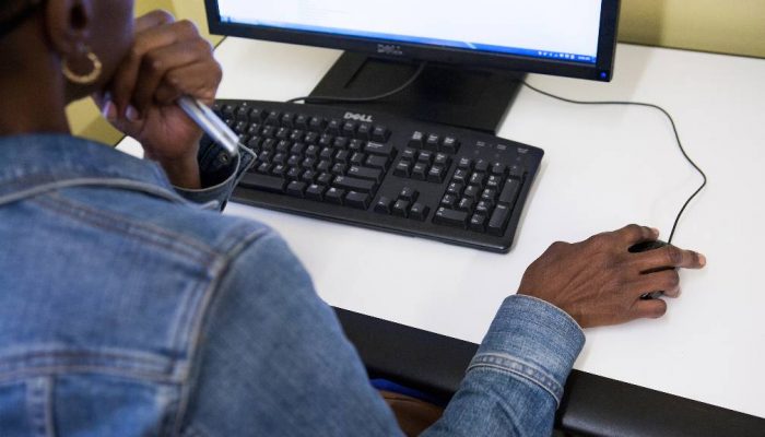 A woman browses a website on a computer