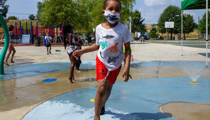 camper runs through sprayground