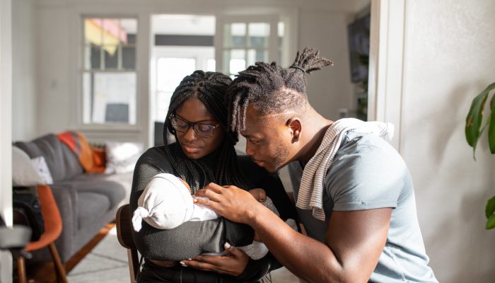 A man and woman look at a baby