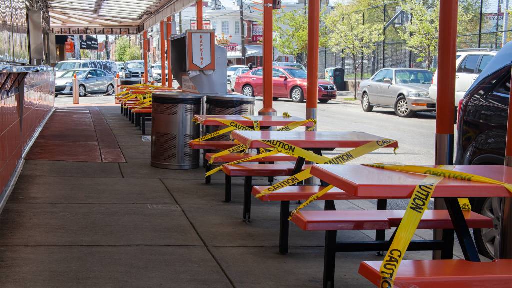 Tables outside a South Philly restaurant are closed off with tape so clients will not use them during COVID-19 pandemic