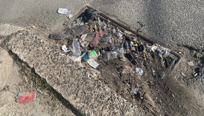 A water inlet filled with dirt and trash