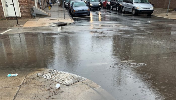 A city street intersection that is flooded with a few inches of water. 