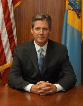 Shane Creamer sits at a table, looking into a camera