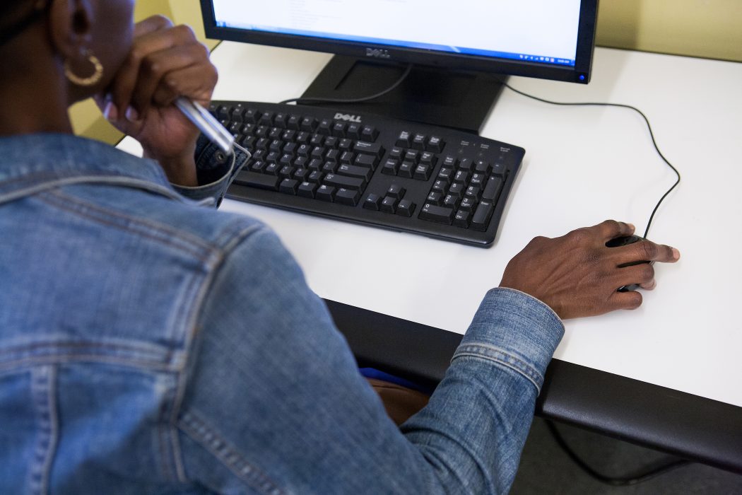A behind the shoulder shot of a person using a computer.