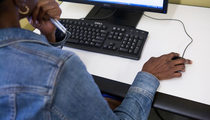 A behind the shoulder shot of a person using a computer.