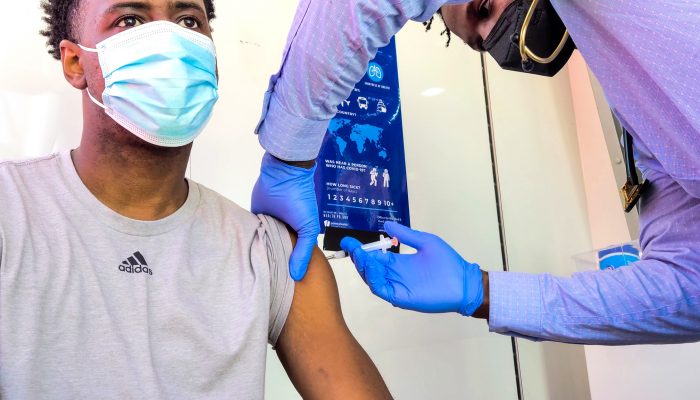 Young African American man who is wearing a mask and being vaccinated