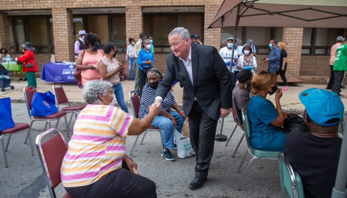 Mayor Kenney shaking hands with a resident