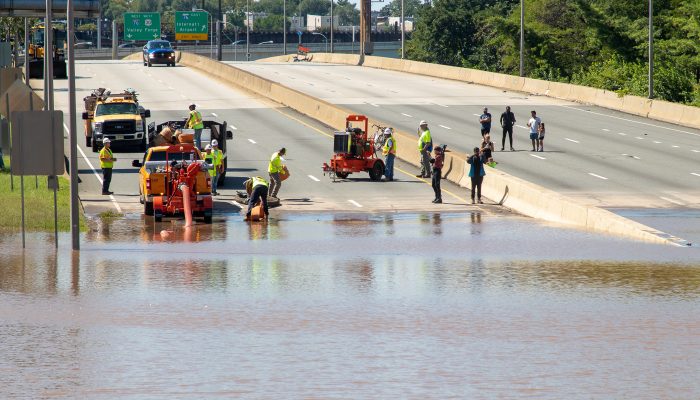 workers responding to a flooded roadway